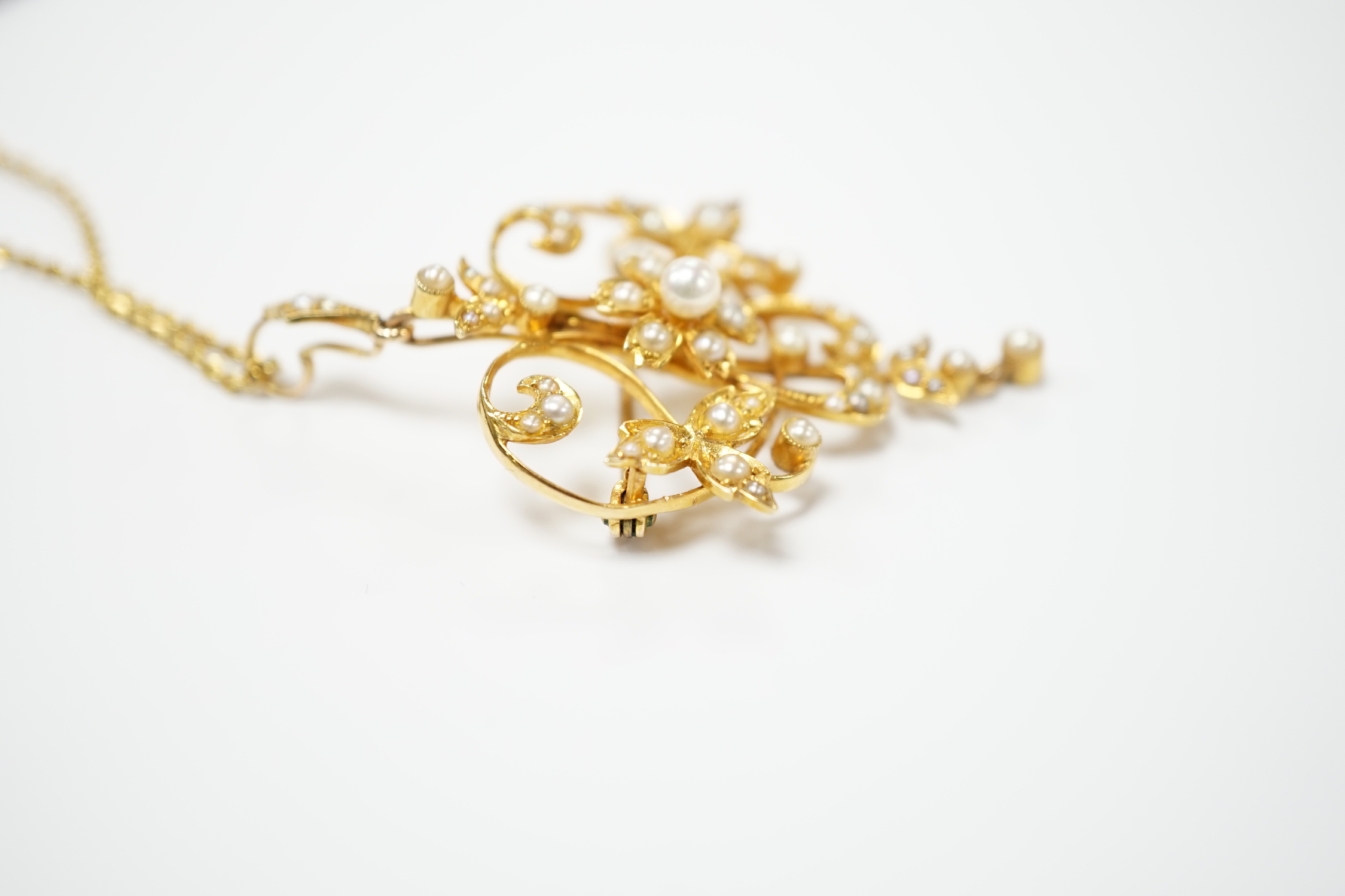 An Edwardian 15ct and seed pearl cluster set drop pendant brooch, 40mm on a later 375 chain.